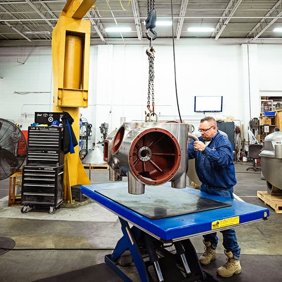 Separators employee unloading a centrifuge part from a crane