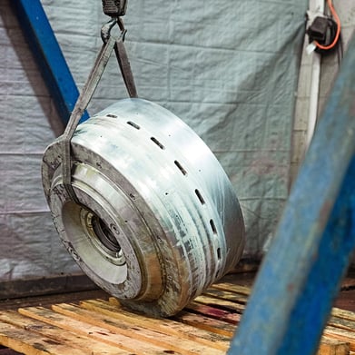 heavy centrifuge piece being pick up from wood pallet with a crane