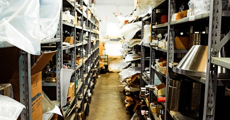 Centrifuge spare parts sit on metal shelves in warehouse