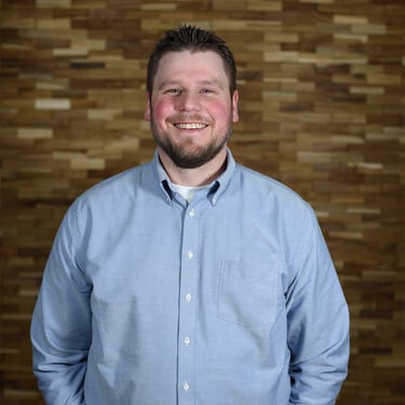 Quenton Lind in dress shirt smiles at camera