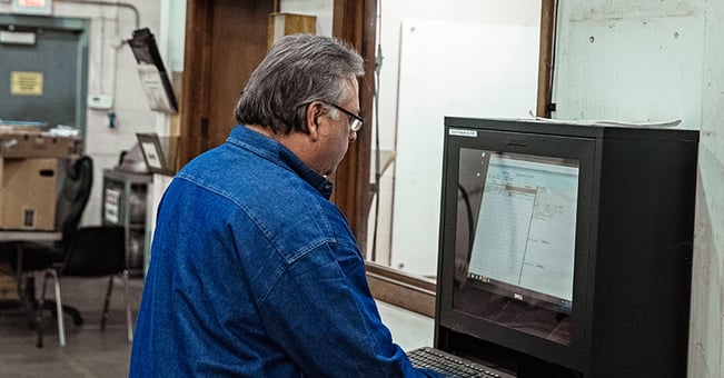 Separators employee looks at screen as he repairs centrifuge