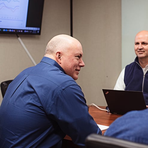 Separators employees sit around conference table