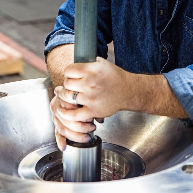 Hands inspect spindle in industrial centrifuge