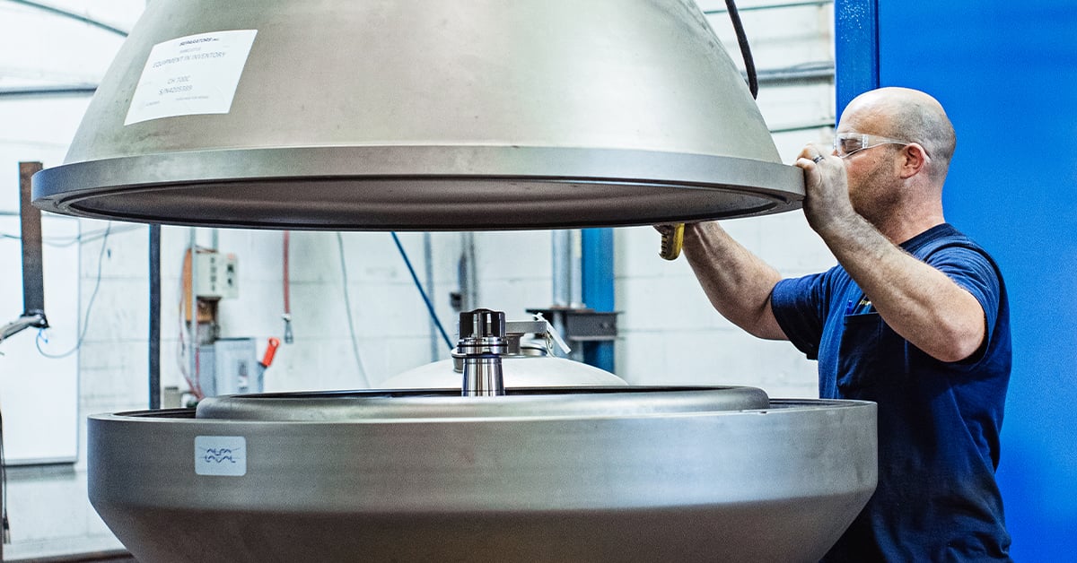 Separators employee opens centrifuge bowl in shop