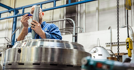 Separators technician works on centrifuge bowl in shop